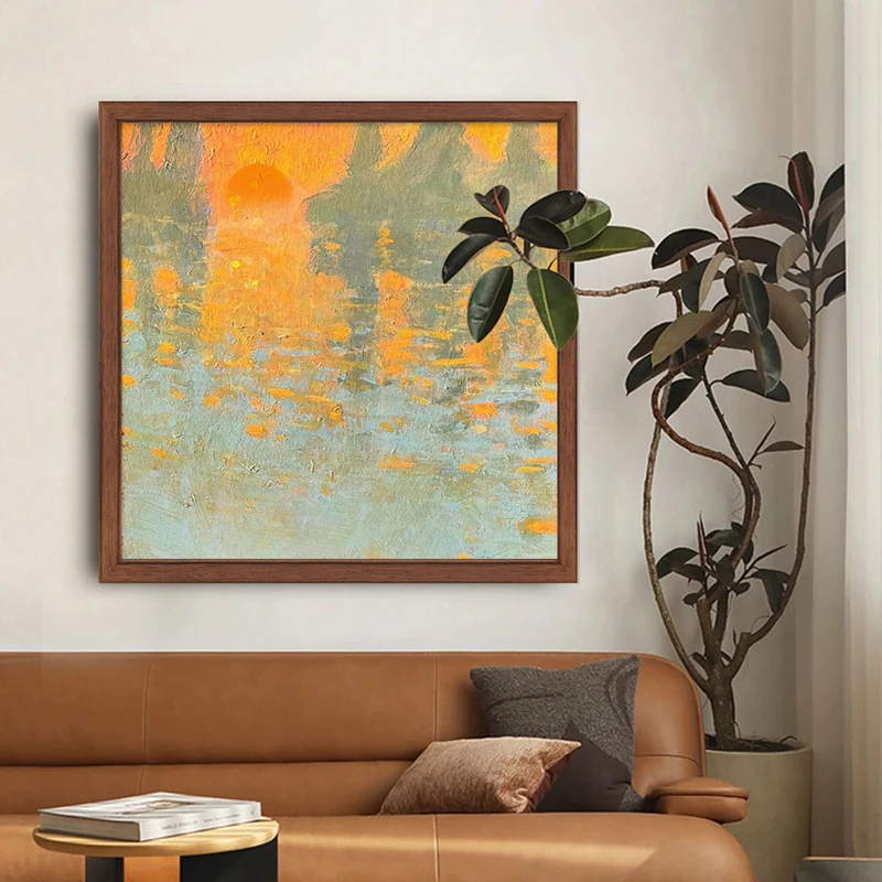 Sunrise waterscape wall art displayed above a tan sofa