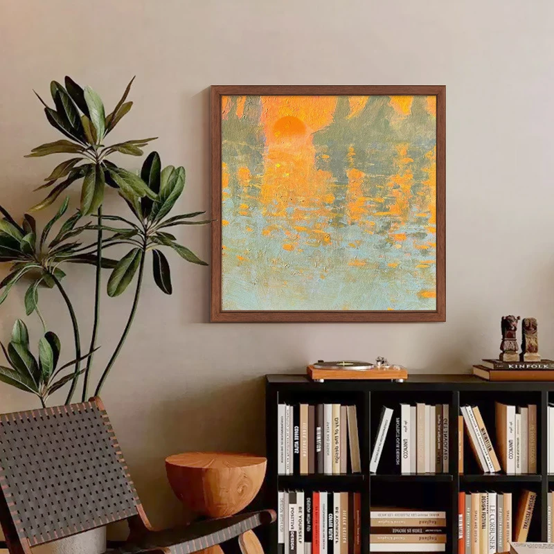 Warm sunrise wall art displayed above a low bookshelf